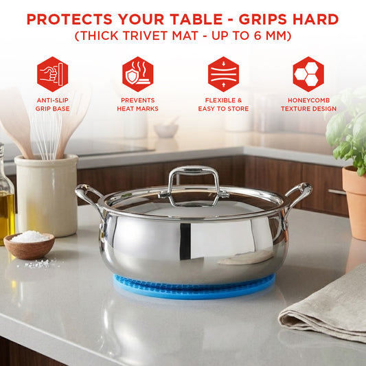 Stainless steel pot on a thick trivet mat with kitchen items in the background