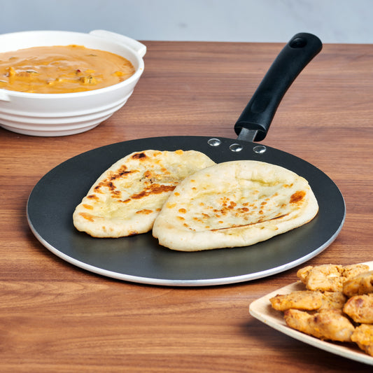 A black non-stick concave tawa with a riveted bakelite handle
