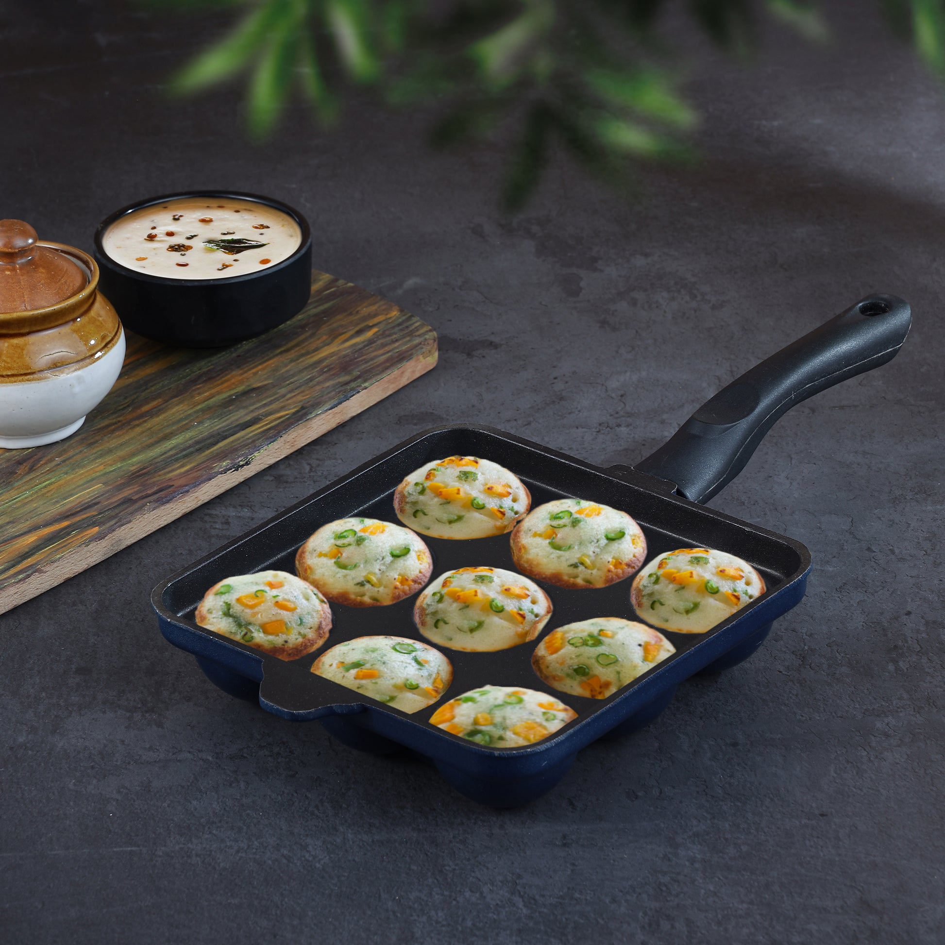 Nonstick appam pan with cooked appams and ergonomic handle, ideal for preparing healthy snacks and breakfast dishes.