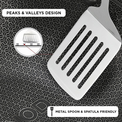 White spatula with peaks and valleys design on a textured black background