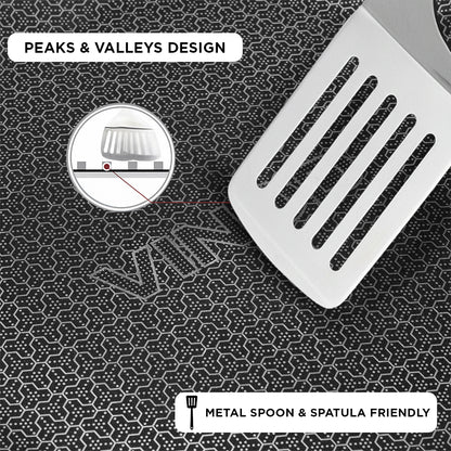 Metal spatula on a textured surface with 'Peaks & Valleys Design' text and 'Metal Spoon & Spatula Friendly' label.