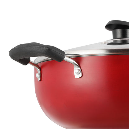 Close-up of a red nonstick kadai showing a sturdy side handle and glass lid with a secure metal fitting.