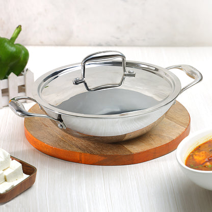 A silver-colored Vinod Platinum triply stainless steel kadai with a lid, displayed on a wooden surface.